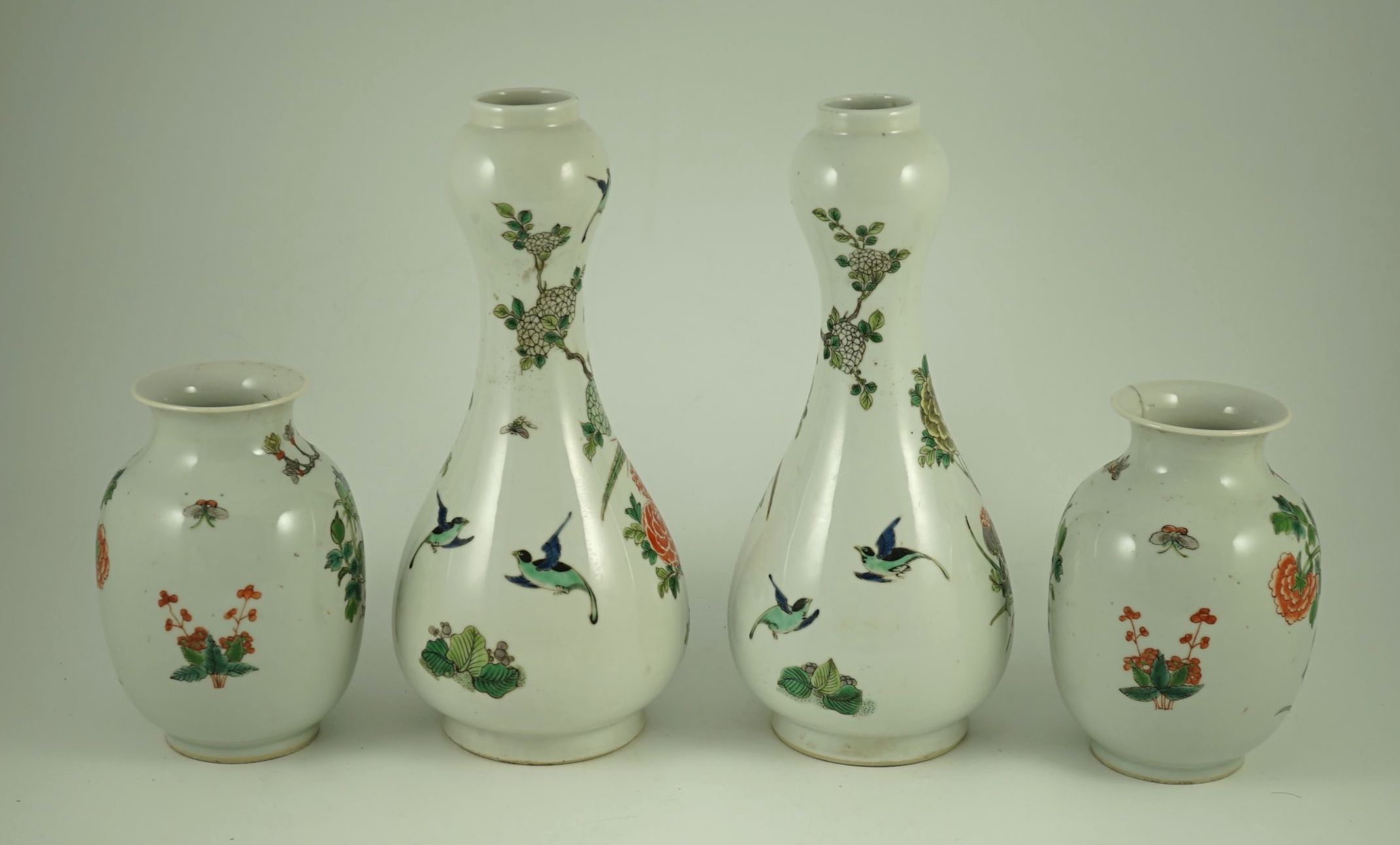 A garniture of four Chinese famille verte vases, 19th century, 31 cm and 17.5 cm high, one small vase cracked to neck
